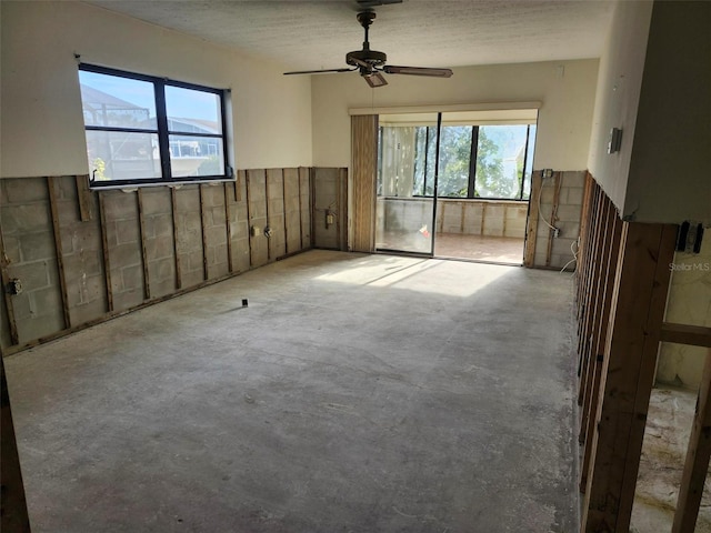 spare room featuring a ceiling fan and unfinished concrete floors