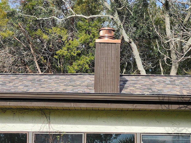 exterior details with gutters and roof with shingles