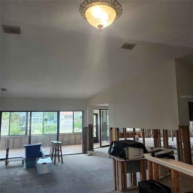 living area featuring concrete flooring, lofted ceiling, and visible vents