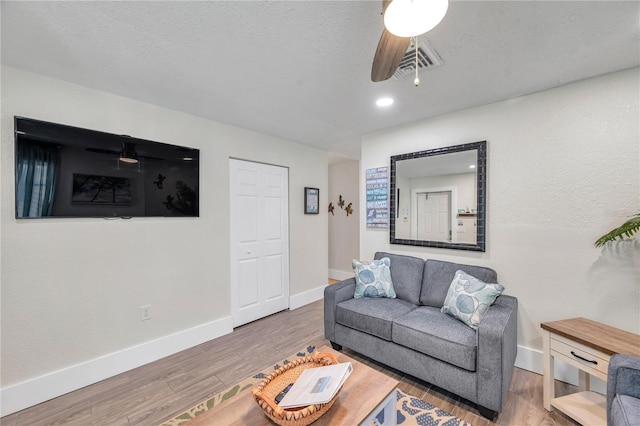 living room with wood-type flooring and a textured ceiling