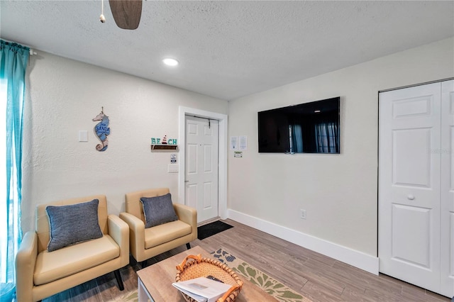 living room with wood-type flooring and a textured ceiling