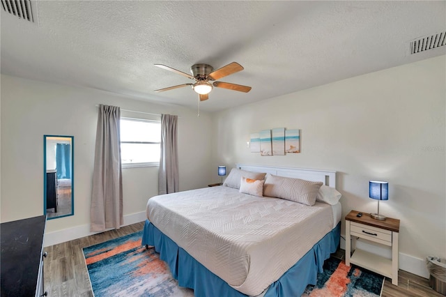 bedroom featuring ceiling fan, hardwood / wood-style floors, and a textured ceiling