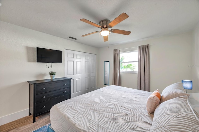 bedroom featuring light hardwood / wood-style flooring, a closet, and ceiling fan