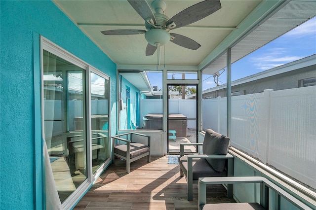 unfurnished sunroom featuring ceiling fan