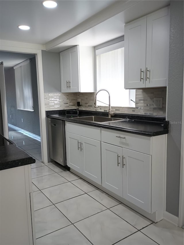 kitchen with backsplash, stainless steel dishwasher, sink, and white cabinets