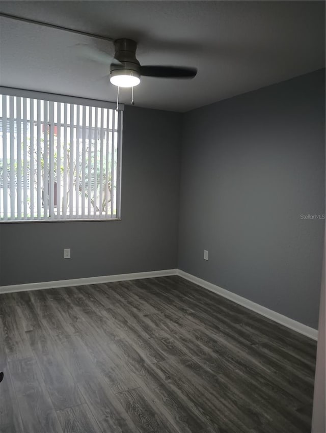 unfurnished room with dark hardwood / wood-style floors and ceiling fan