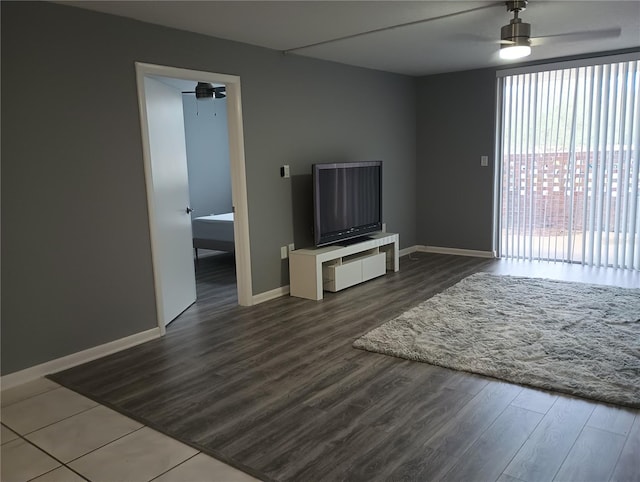 unfurnished living room featuring dark wood-type flooring and ceiling fan