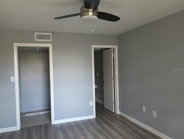 unfurnished bedroom with ceiling fan, dark wood-type flooring, and a textured ceiling