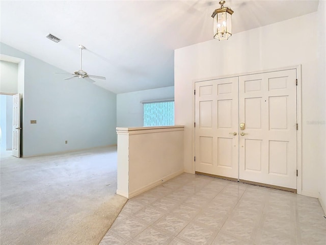 carpeted entryway featuring lofted ceiling and ceiling fan with notable chandelier