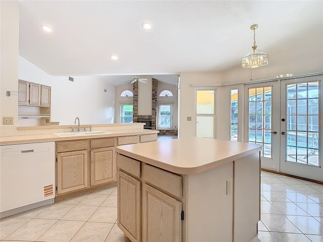 kitchen featuring light tile patterned flooring, light brown cabinetry, sink, a center island, and white dishwasher