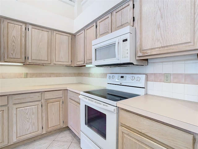 kitchen with tasteful backsplash, white appliances, and light brown cabinets