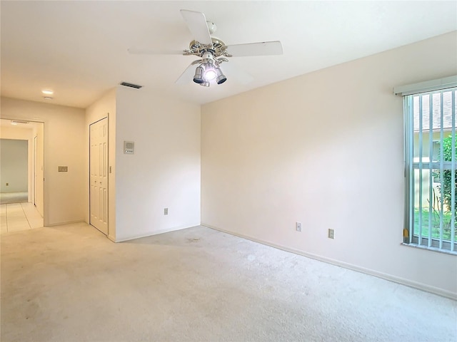 unfurnished room with light colored carpet and ceiling fan