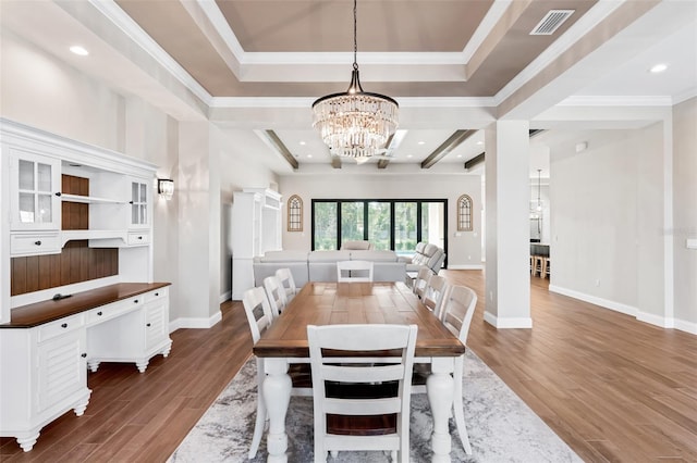 dining space with an inviting chandelier, crown molding, dark hardwood / wood-style flooring, and a raised ceiling