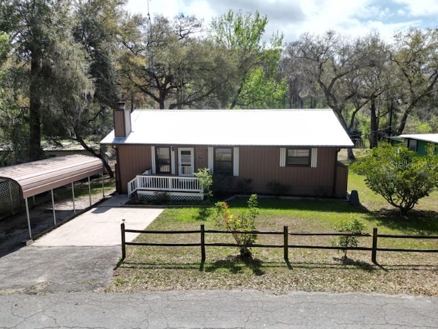 ranch-style home featuring a front yard, a carport, and a porch