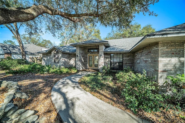 3013 Ridgevale Cir, Valrico, FL 33596 - view of front of house with french doors, a shingled roof, and brick siding