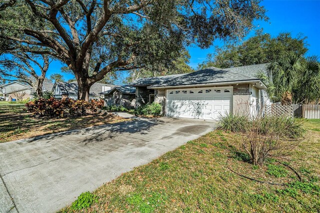 3013 Ridgevale Cir, Valrico, FL 33596 - view of front of house featuring a shingled roof, an attached garage, fence, brick siding, and driveway