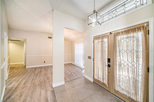 3013 Ridgevale Cir, Valrico, FL 33596 - entrance foyer with a textured ceiling, visible vents, a chandelier, wood finished floors, and baseboards