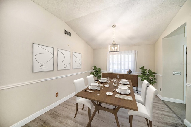 3013 Ridgevale Cir, Valrico, FL 33596 - dining area with visible vents, baseboards, wood finished floors, and vaulted ceiling