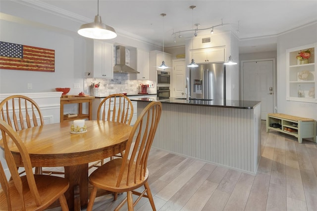 dining area featuring visible vents, ornamental molding, and light wood-style flooring