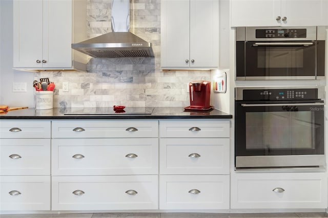 kitchen featuring dark countertops, black electric stovetop, white cabinets, and ventilation hood