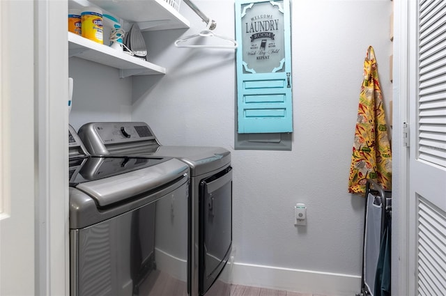 laundry room featuring laundry area, a textured wall, baseboards, and independent washer and dryer