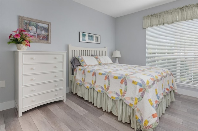 bedroom with baseboards and light wood finished floors