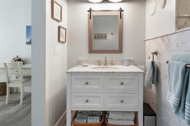 bathroom featuring baseboards, wood finished floors, and vanity