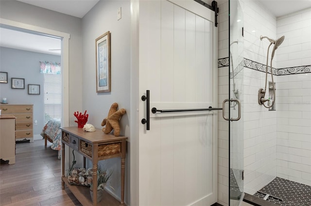 full bathroom with a stall shower, wood finished floors, and ensuite bathroom