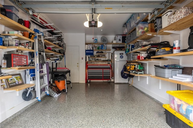 garage featuring a garage door opener, freestanding refrigerator, and a workshop area