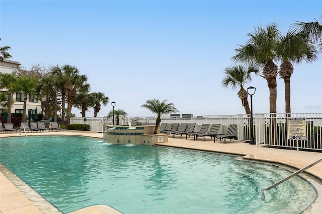 pool featuring a jacuzzi, fence, and a patio