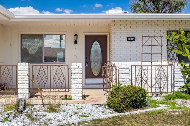 property entrance featuring brick siding