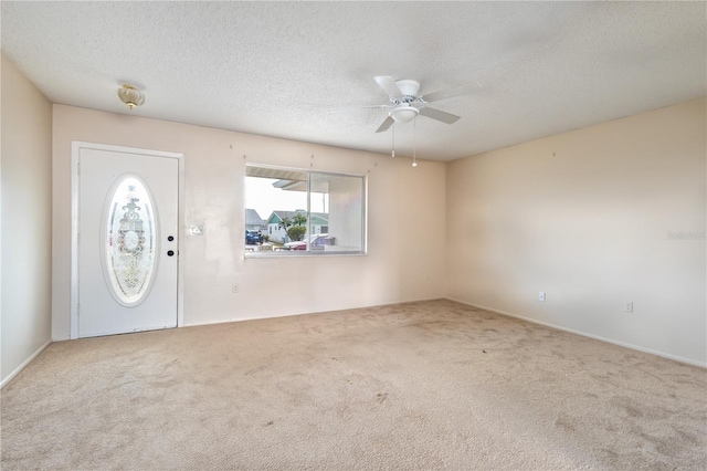 entrance foyer featuring carpet floors, a textured ceiling, and ceiling fan