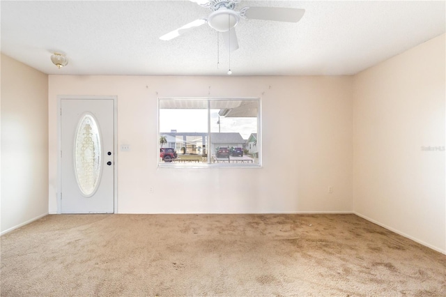 carpeted entrance foyer with ceiling fan and a textured ceiling