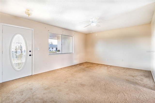 carpeted foyer entrance with ceiling fan