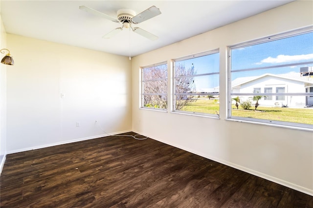 spare room with a ceiling fan, wood finished floors, and baseboards