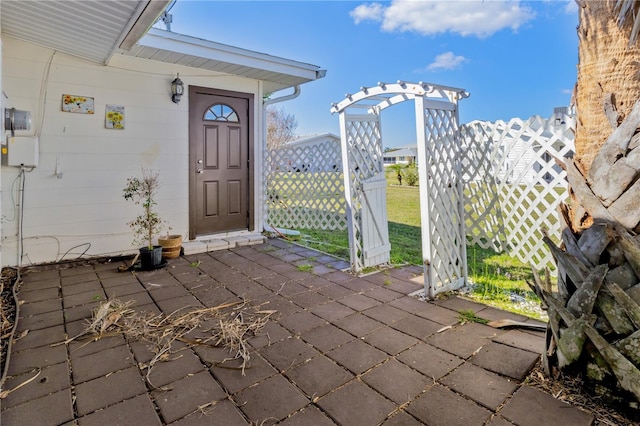 property entrance with a patio and fence