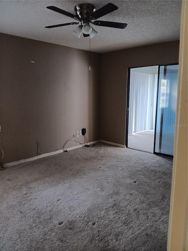 carpeted empty room featuring ceiling fan and a textured ceiling