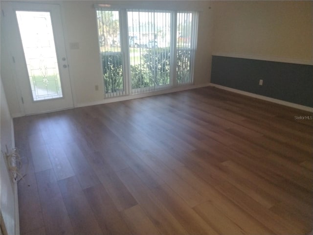 empty room featuring dark hardwood / wood-style flooring and plenty of natural light