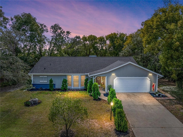 ranch-style house with a yard and a garage