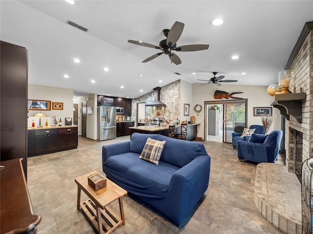 living room featuring vaulted ceiling and a brick fireplace