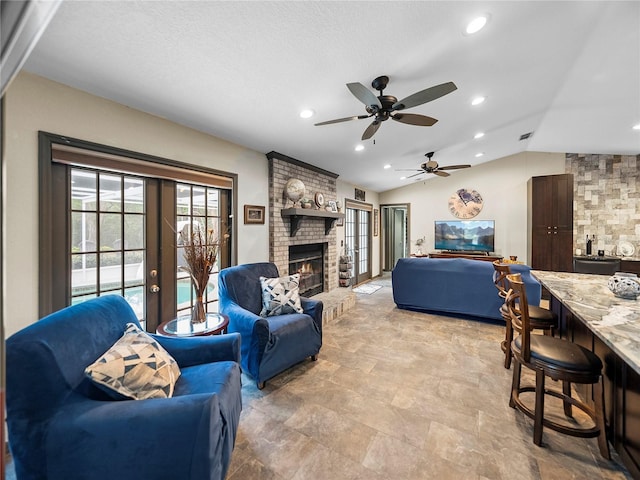 living room featuring a fireplace, french doors, and lofted ceiling