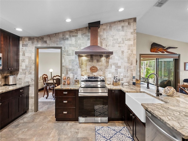 kitchen featuring stainless steel appliances, dark brown cabinetry, sink, vaulted ceiling, and wall chimney exhaust hood