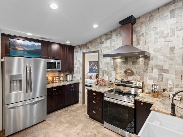 kitchen with sink, wall chimney exhaust hood, stainless steel appliances, and light stone countertops