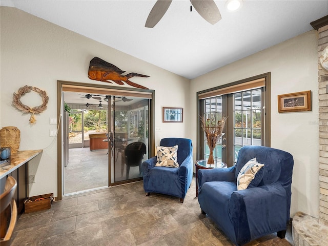 living area with ceiling fan, vaulted ceiling, and plenty of natural light