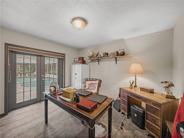 home office with a textured ceiling and french doors