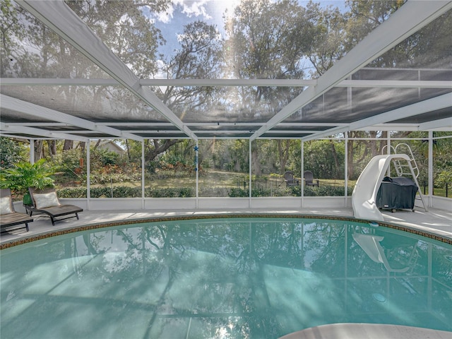 view of swimming pool with a lanai, a patio area, and a water slide