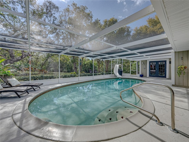 view of swimming pool with a patio, french doors, a water slide, and a lanai