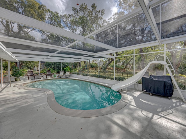 view of pool with a patio area, a water slide, and a lanai