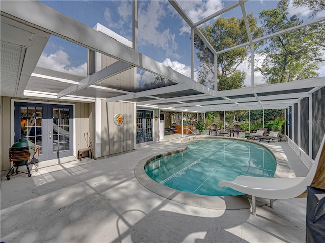 view of swimming pool with a lanai, french doors, a patio area, a grill, and a water slide