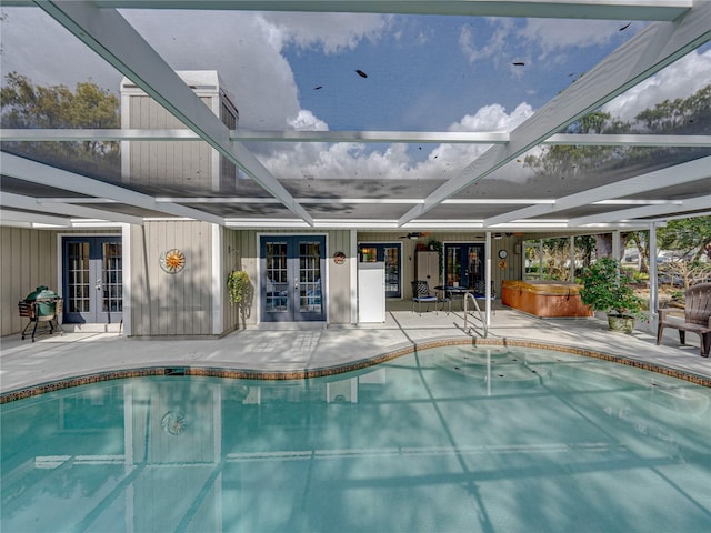 view of pool featuring a patio, french doors, a lanai, and a hot tub